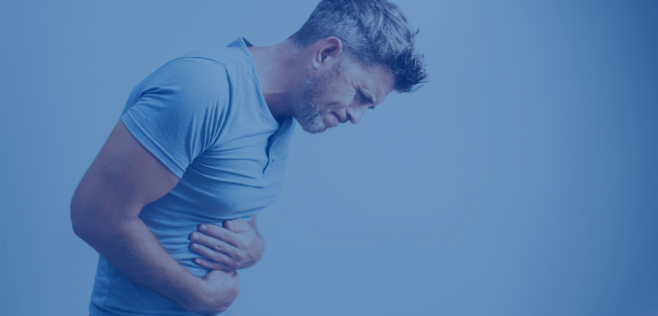 man in blue tee holding stomach doubled over in pain
